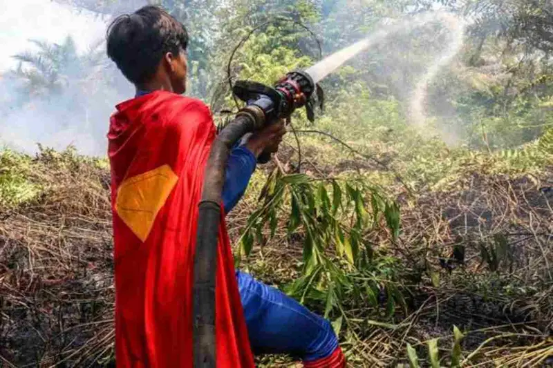 Indonesiano Vestito da Superman Combatte gli Incendi Boschivi